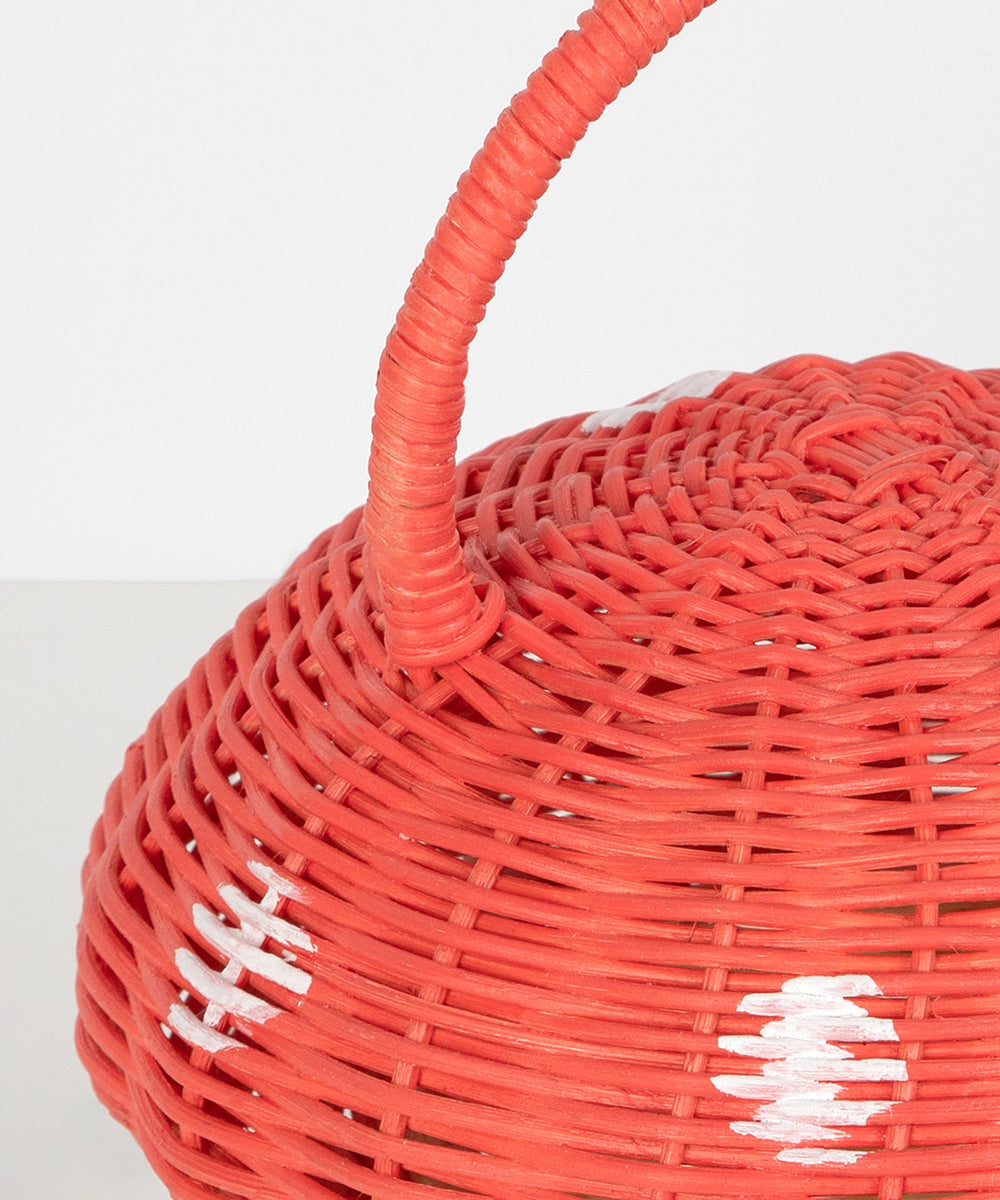Close-up of the Mushroom Basket, featuring a red woven design with a handle and white accents.