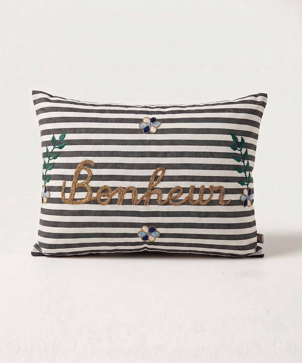 Le Embroidered Pillow - Striped Bonheur features black and white stripes, floral details, and "Bonheur" embroidered in gold.
