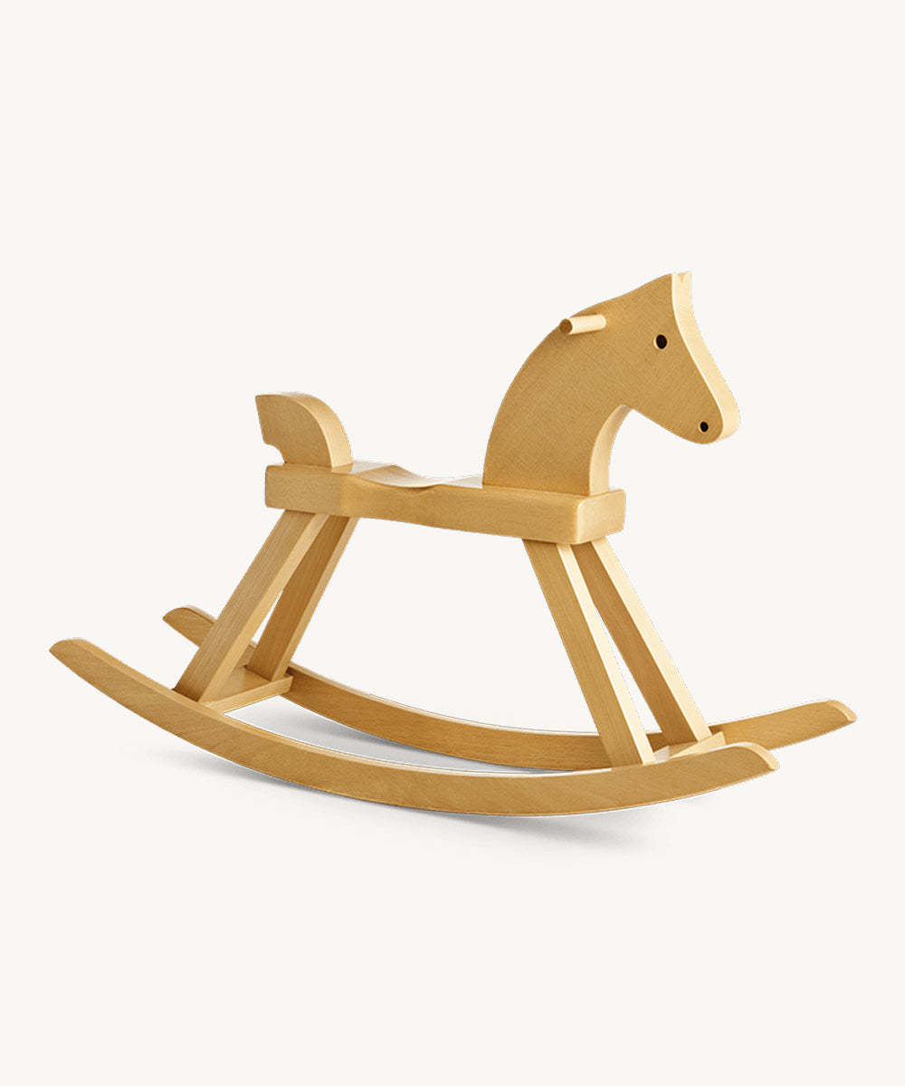 The Kay Bojesen Rocking Horse features a smooth natural finish, minimalist design, and curved rockers, shown in a side view.