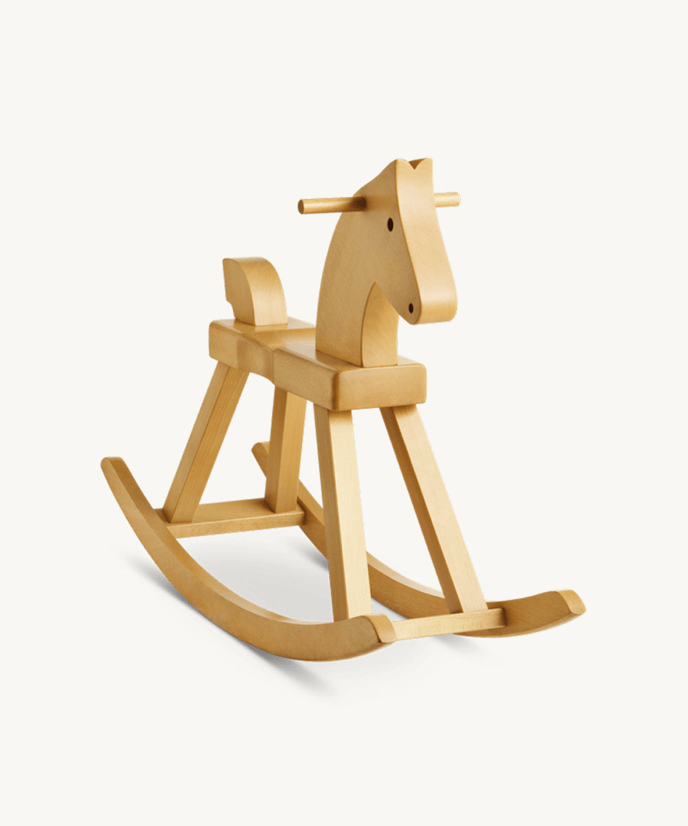The Kay Bojesen Rocking Horse is a light wooden toy with minimalist design, smooth finish, and curved rockers, shown on a plain white background.