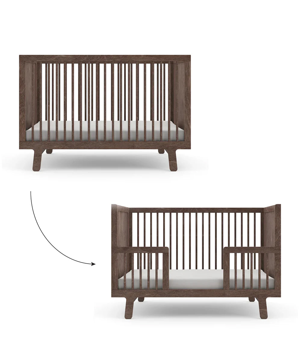 The Sparrow Crib transforms into a toddler bed with the Sparrow Toddler Bed Conversion Kit, featuring slatted sides and a simple design crafted from sustainable materials.