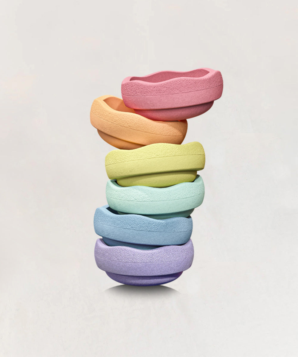 Le Original Rainbow: a stack of six pastel-colored, textured rings arranged vertically against a plain light background.