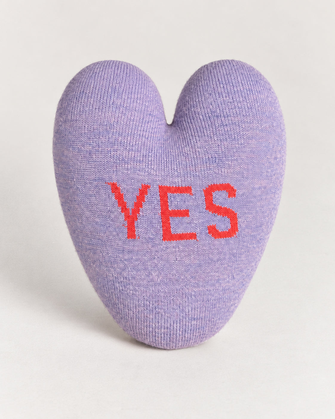 Yes/No Heart Pillow in lavender shaped like a heart with the word “YES” in red letters.