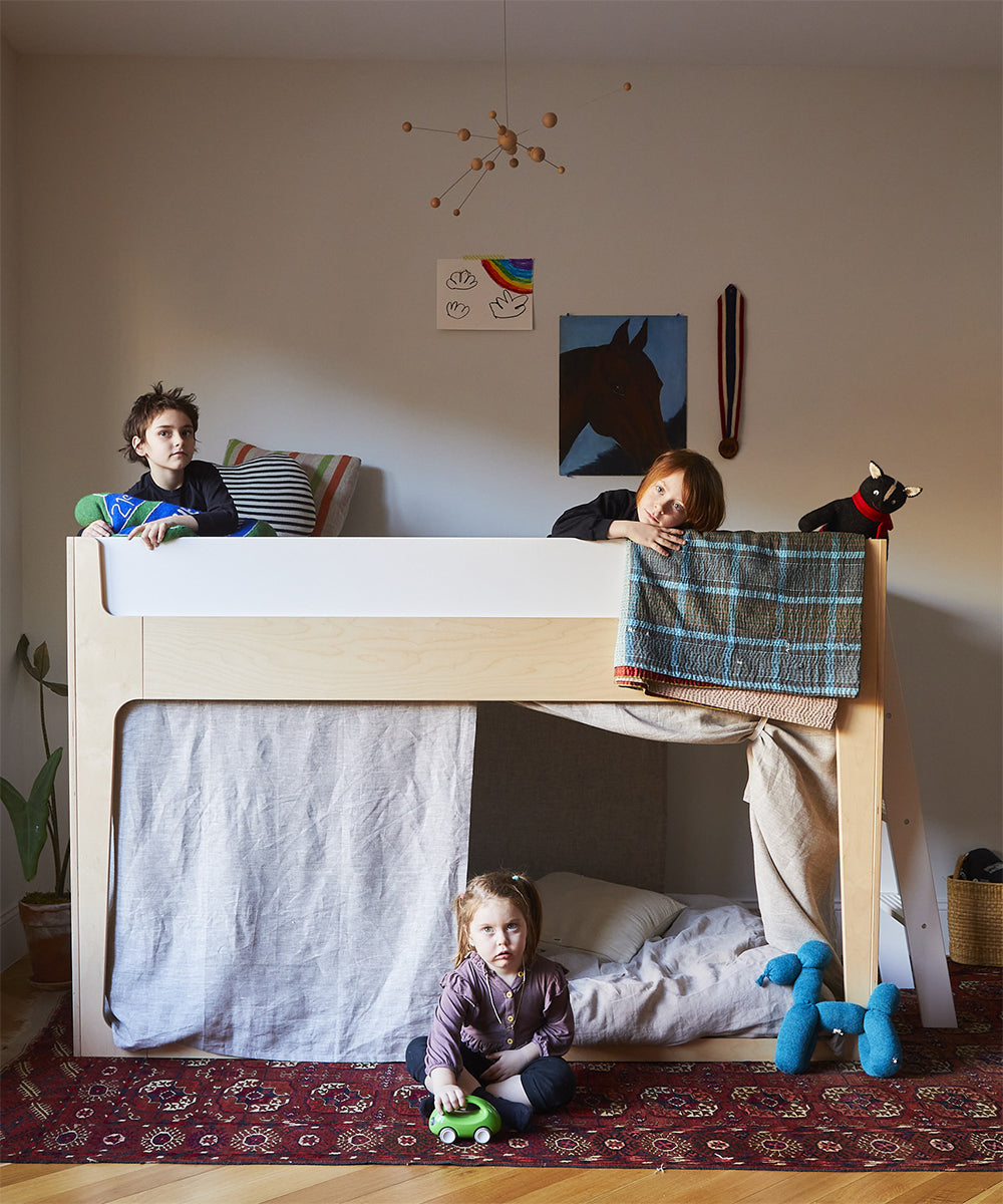 three kids in the Nest Loft bed looking serious